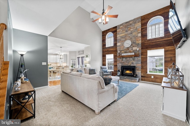 25 Mica St, Townsend, DE 19734 - living area featuring a stone fireplace, carpet floors, wood walls, ceiling fan, and high vaulted ceiling