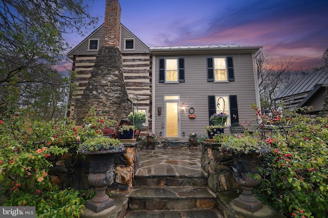 view of front of house with a patio area and a chimney