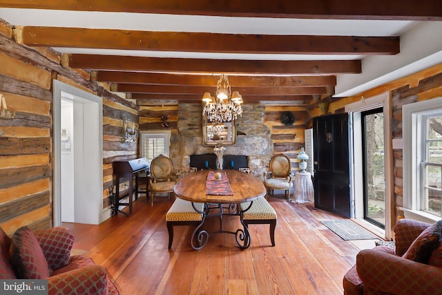 living area featuring a chandelier, a healthy amount of sunlight, hardwood / wood-style flooring, and beamed ceiling