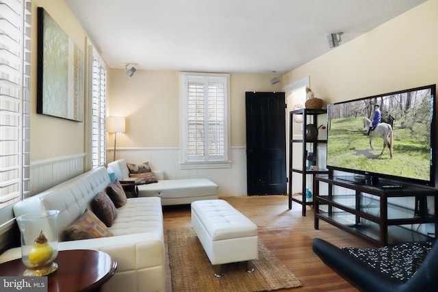 living area with wood finished floors and wainscoting