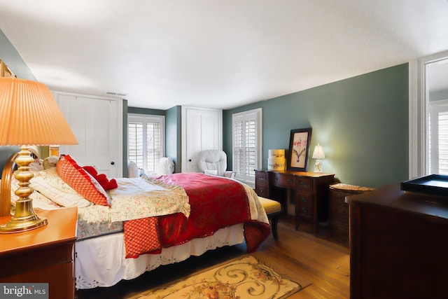 bedroom featuring wood finished floors and visible vents