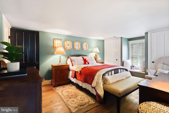 bedroom with wood-type flooring and baseboards