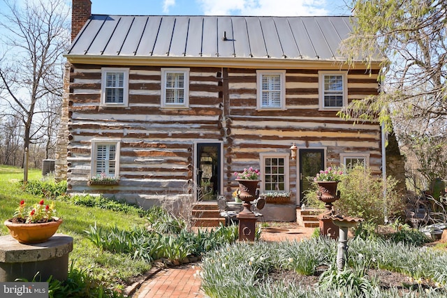 log home featuring a standing seam roof, cooling unit, a chimney, metal roof, and log exterior