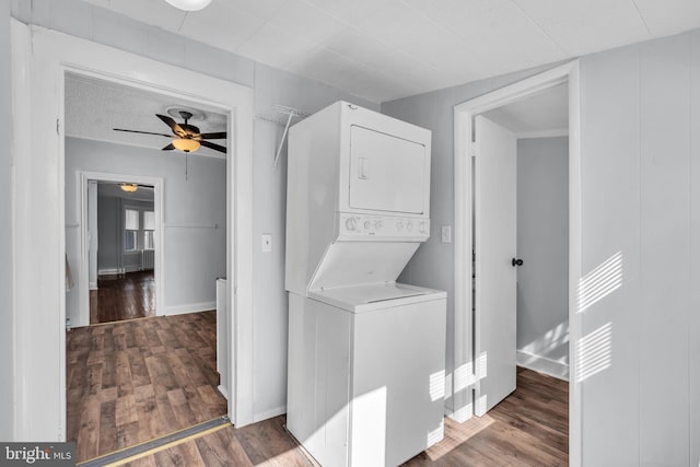 laundry room with baseboards, stacked washer / dryer, laundry area, ceiling fan, and wood finished floors