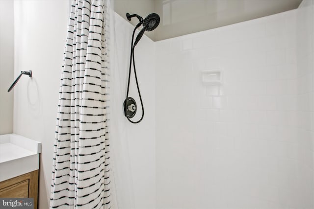 full bath featuring vanity and tiled shower