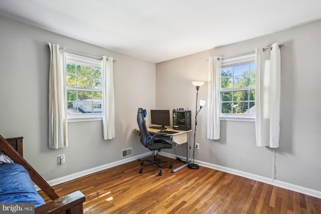 office with baseboards, wood finished floors, and visible vents
