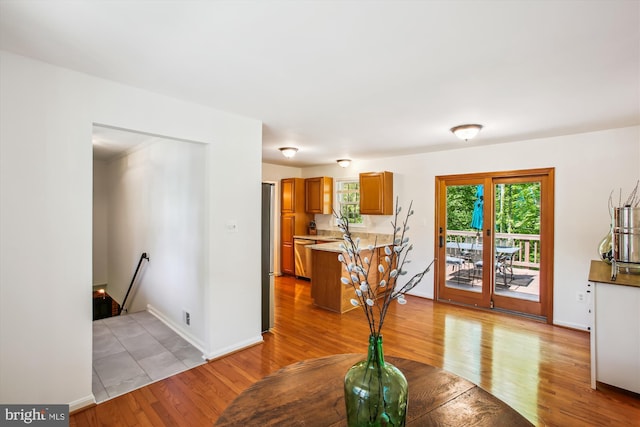 interior space featuring a sink, baseboards, brown cabinetry, and light wood-type flooring
