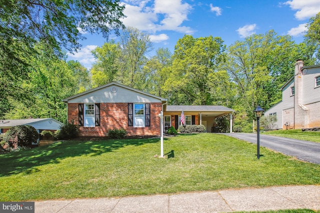 view of front of house featuring an attached carport, brick siding, driveway, and a front lawn