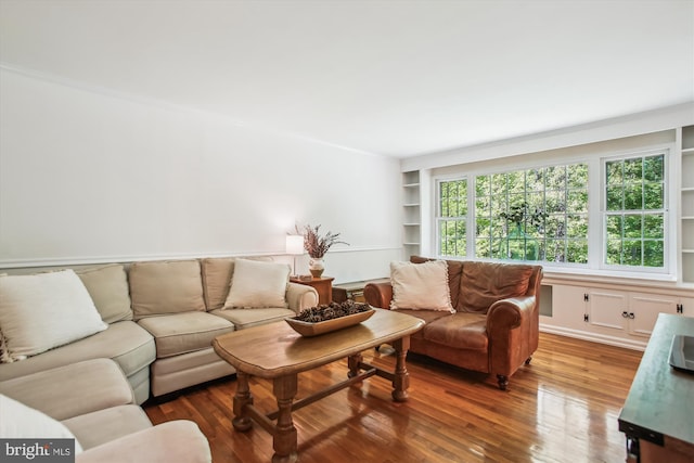 living room with built in features and wood finished floors