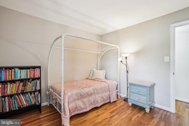 bedroom featuring baseboards and wood finished floors