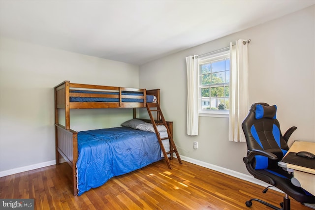 bedroom with baseboards and wood finished floors