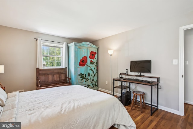 bedroom featuring baseboards, wood finished floors, and visible vents