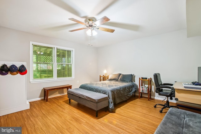 bedroom with baseboards, a ceiling fan, and light wood-style flooring
