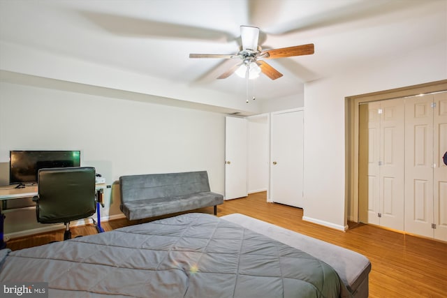 bedroom featuring baseboards, ceiling fan, a closet, and wood finished floors