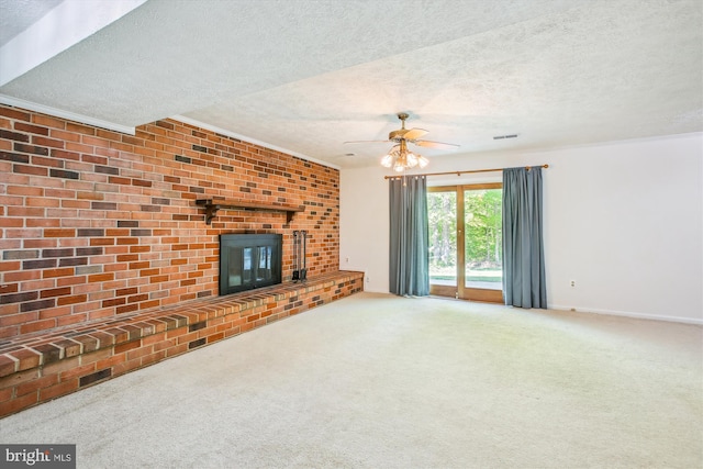 unfurnished living room with a ceiling fan, a textured ceiling, a brick fireplace, and carpet