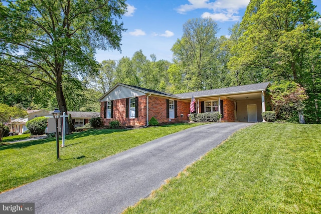 ranch-style home with brick siding, an attached carport, driveway, and a front yard