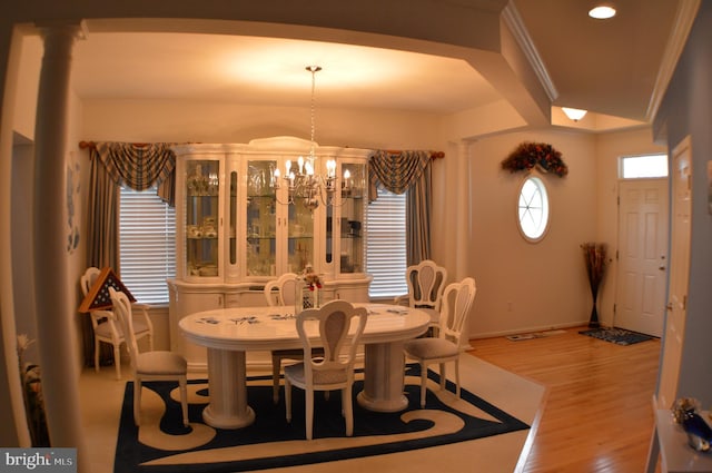 dining space with baseboards, a chandelier, and wood finished floors
