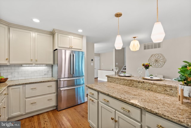 8620 Conover Pl, Alexandria, VA 22308 - kitchen featuring freestanding refrigerator, light wood finished floors, backsplash, pendant lighting, and recessed lighting