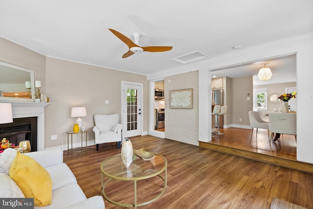 8620 Conover Pl, Alexandria, VA 22308 - living area with a fireplace, wood finished floors, a ceiling fan, baseboards, and attic access