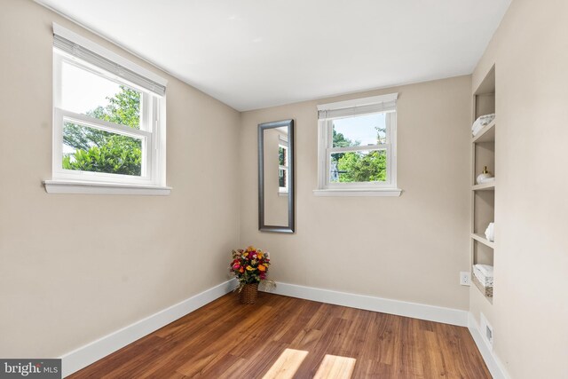 8620 Conover Pl, Alexandria, VA 22308 - empty room with healthy amount of natural light, baseboards, and wood finished floors