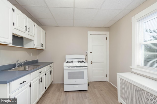 33 E Isabel Ave, Glenolden, PA 19036 - kitchen with white range with gas cooktop, a paneled ceiling, a sink, light wood-style flooring, and radiator heating unit