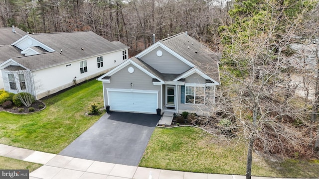 166 Blackburn St, Absecon, NJ 08205 - view of front facade with an attached garage, a front lawn, driveway, and a wooded view