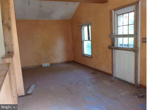 interior space featuring vaulted ceiling and baseboards