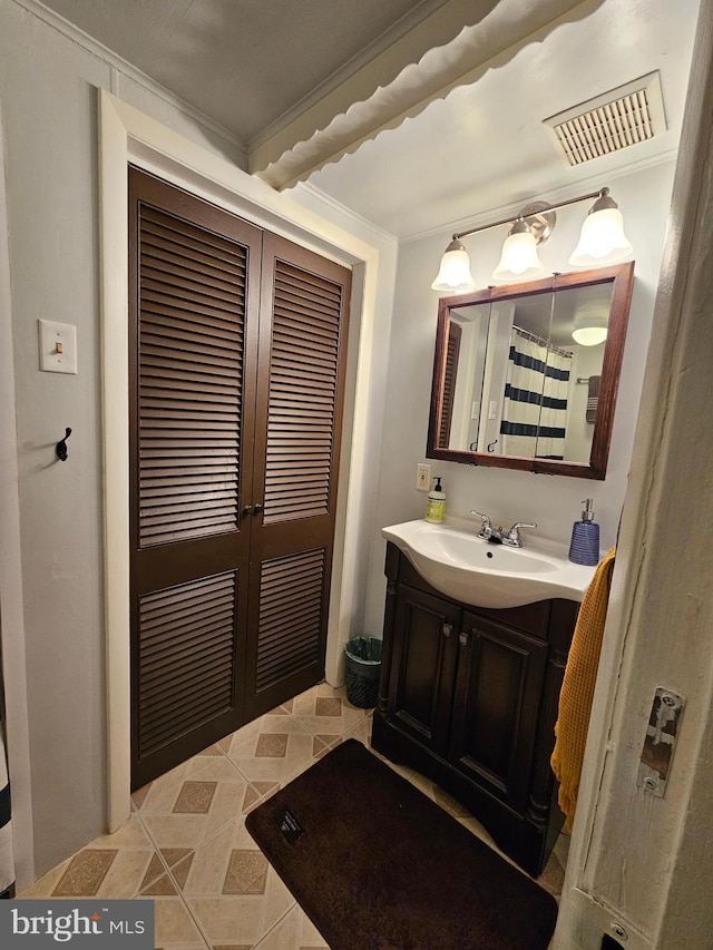bathroom featuring crown molding, visible vents, and vanity