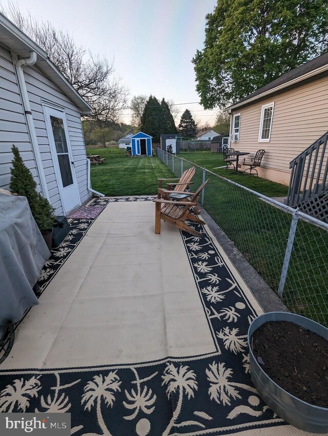 view of patio / terrace with a storage unit, an outdoor structure, area for grilling, and fence