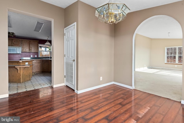 6335 Oxford Rd, Gardners, PA 17324 - unfurnished dining area with baseboards, arched walkways, and hardwood / wood-style flooring