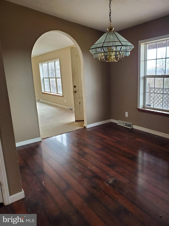6335 Oxford Rd, Gardners, PA 17324 - unfurnished dining area featuring arched walkways, a notable chandelier, visible vents, and hardwood / wood-style floors