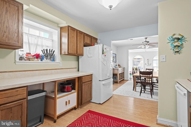5984 2nd St, Deale, MD 20751 - kitchen featuring light wood-type flooring, brown cabinetry, white appliances, and plenty of natural light