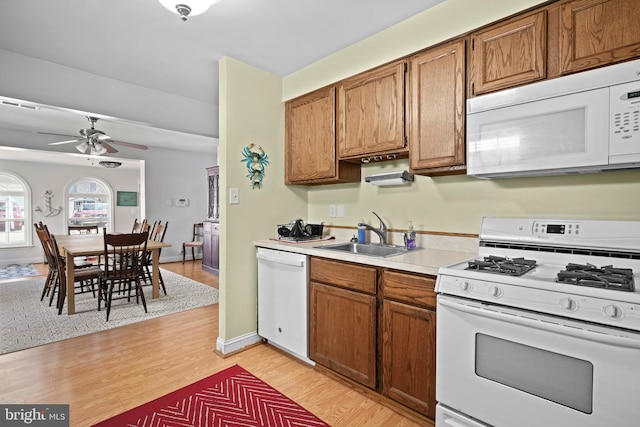 5984 2nd St, Deale, MD 20751 - kitchen featuring light countertops, white appliances, a sink, and brown cabinets