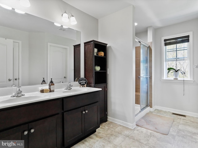 bathroom with visible vents, a sink, and a shower stall