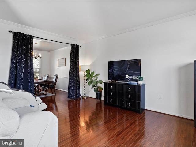living room featuring hardwood / wood-style floors, baseboards, an inviting chandelier, and crown molding