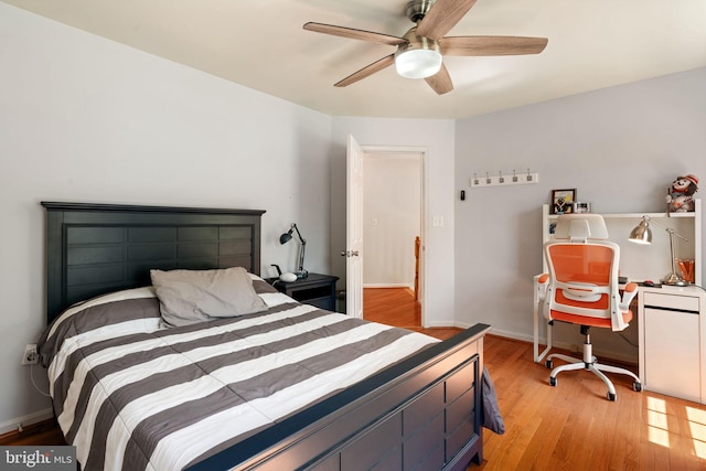bedroom featuring wood finished floors, a ceiling fan, and baseboards