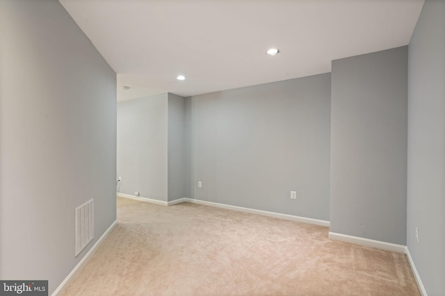 spare room with recessed lighting, visible vents, baseboards, and light carpet