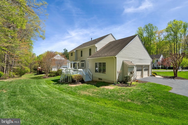 rear view of house with a deck, aphalt driveway, a yard, and a garage