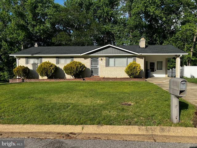 single story home featuring brick siding, a carport, a front lawn, and a chimney