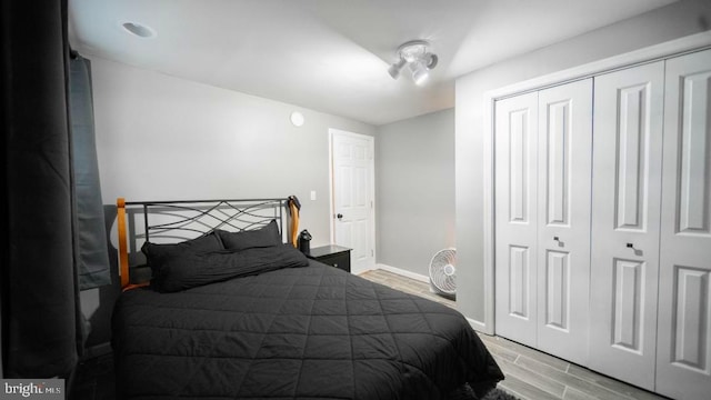 bedroom featuring light wood-style flooring, a closet, and baseboards