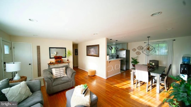 living room featuring wood finished floors, baseboards, and recessed lighting
