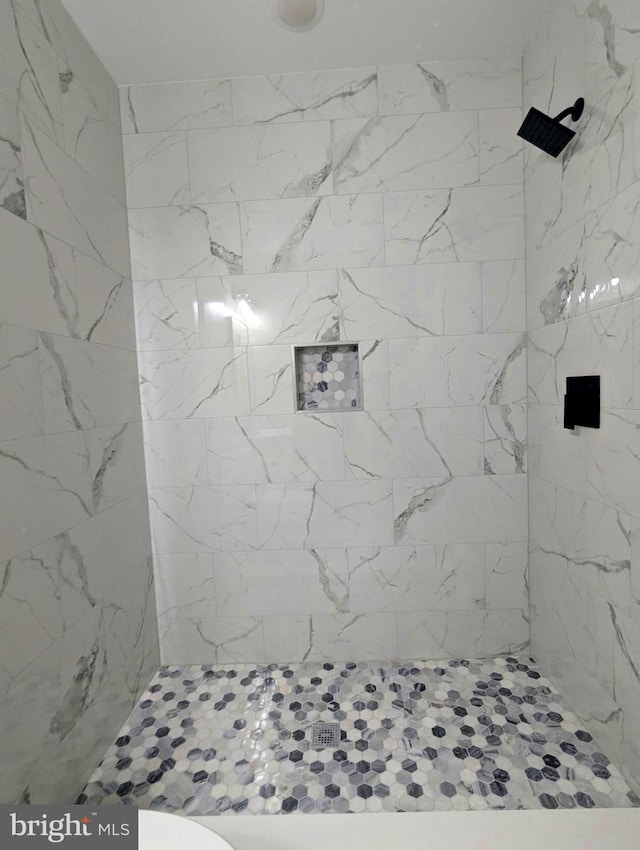 full bath with a tile shower