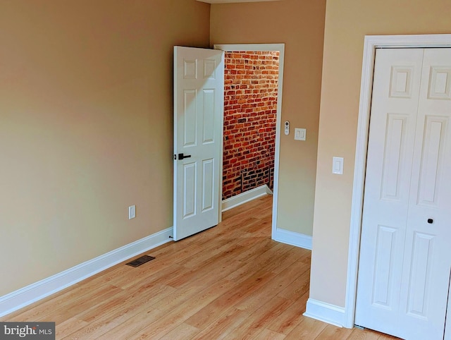 1102 S Carey St, Baltimore, MD 21223 - unfurnished bedroom featuring baseboards, light wood-style flooring, and a closet