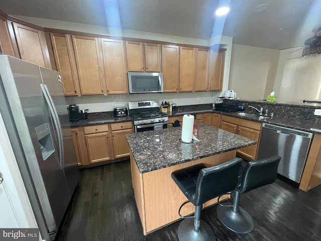 506 Victorianna Dr, Capitol Heights, MD 20743 - kitchen with a breakfast bar, appliances with stainless steel finishes, a sink, dark wood-style floors, and a center island