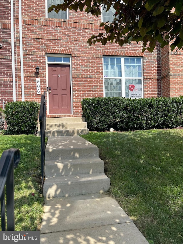 506 Victorianna Dr, Capitol Heights, MD 20743 - view of exterior entry featuring brick siding and a yard
