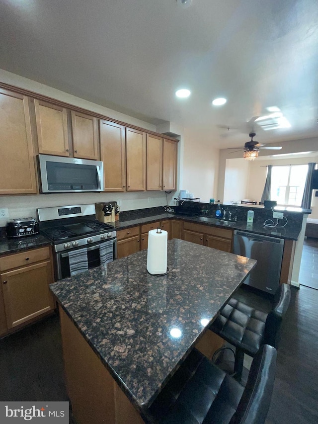 506 Victorianna Dr, Capitol Heights, MD 20743 - kitchen featuring a breakfast bar area, dark stone counters, a ceiling fan, a peninsula, and appliances with stainless steel finishes