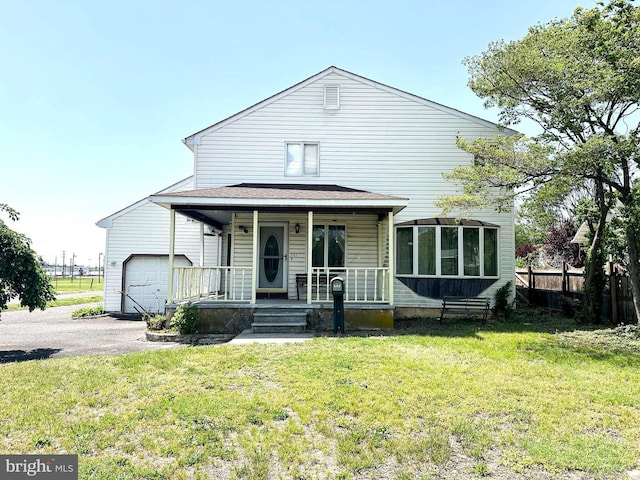 502 N W Ave, Vineland, NJ 08360 - view of front of house featuring a front yard, a porch, fence, and a garage