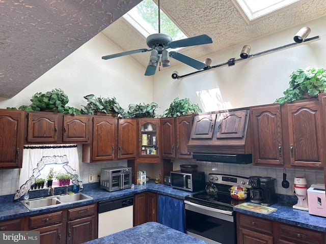 502 N W Ave, Vineland, NJ 08360 - kitchen with a sink, stainless steel appliances, decorative backsplash, lofted ceiling with skylight, and dark countertops