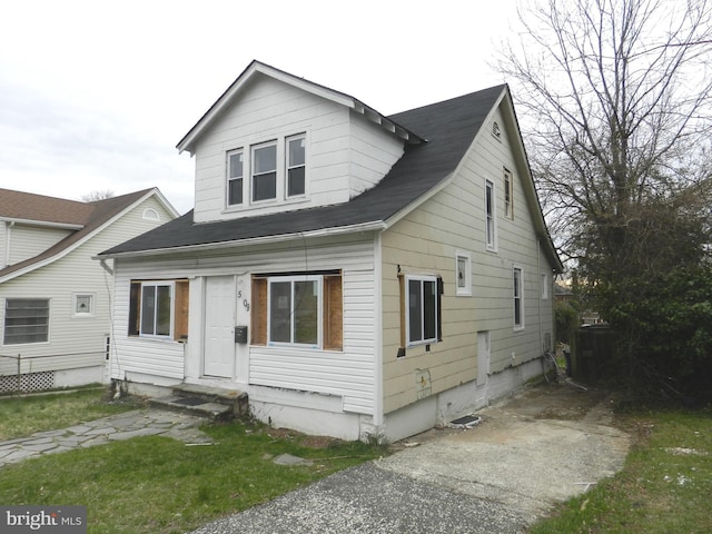 bungalow-style home featuring roof with shingles and entry steps