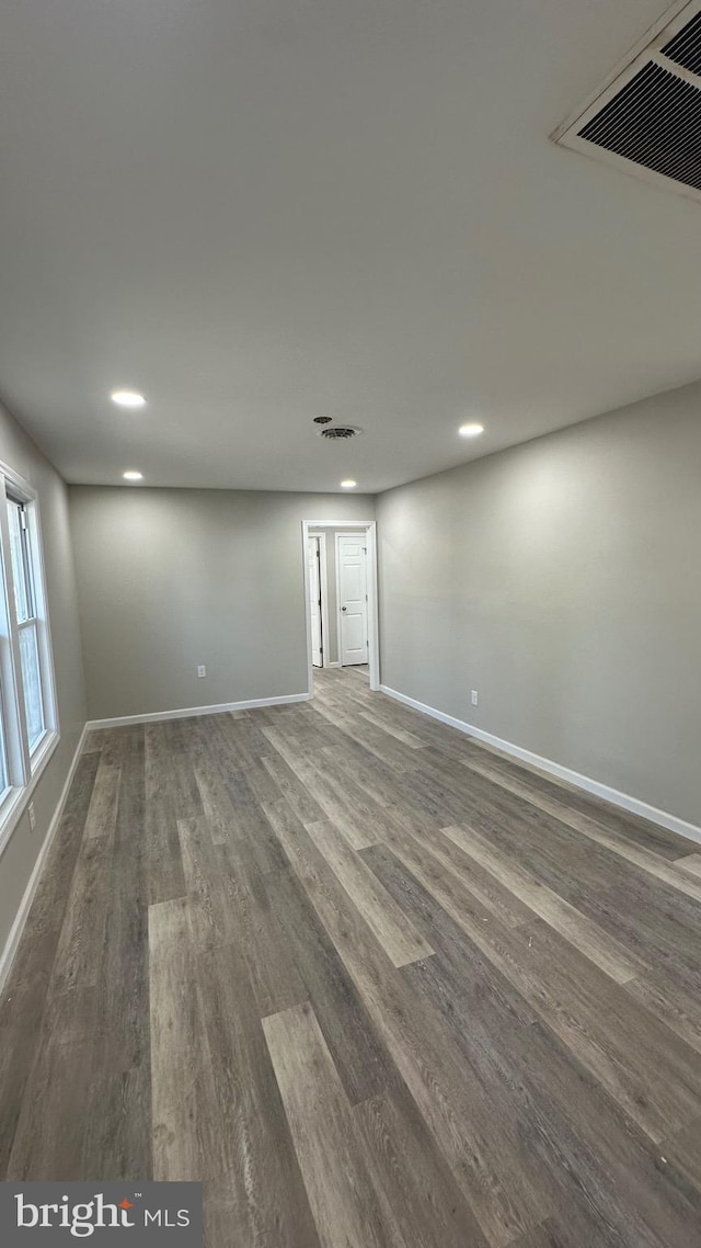 interior space featuring recessed lighting, visible vents, baseboards, and dark wood-style floors